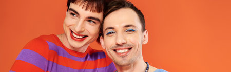 jolly gay friends with vivid makeup posing together on orange backdrop, pride month, banner