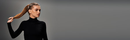 A striking portrait of a young, beautiful woman with a ponytail, dressed in a sleek black dress, exuding elegance and poise.の写真素材