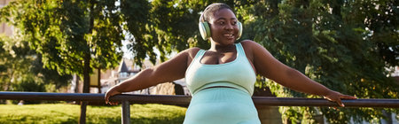 An African American woman leaning on a rail, embodying confidence and relaxation outdoors.