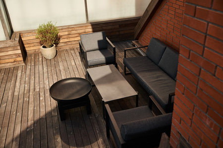 A stylish arrangement of a couch and chairs on a polished wooden floor, creating a warm and inviting atmosphere in a roomの写真素材