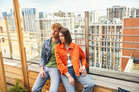 A man and a woman sitting side by side on a wooden bench, enjoying a peaceful moment in natureの写真素材