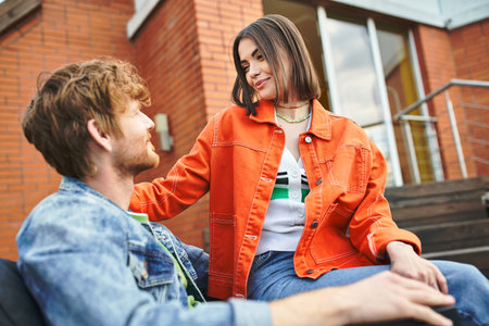 A man and a woman sitting on a bench, engaged in a conversation, sharing thoughts, emotions, and experiencesの写真素材
