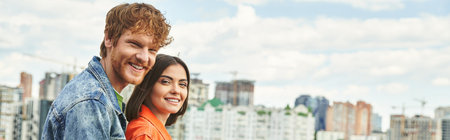A man and a woman stand before a sprawling city skyline, gazing out at the towering buildings in awe and wonderの写真素材