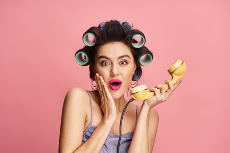 Stylish woman with curlers in her hair, holding a retro phone with confidence.
