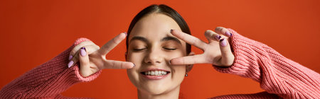 A brunette teenage girl in casual attire holds her hands in front of her eyes, creating a veil-like...