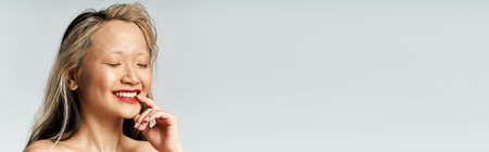 An attractive Asian woman smiles while posing.