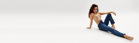 A captivating, bare woman gracefully seated on the floor.の写真素材