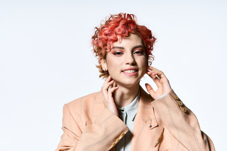 A striking red-haired woman poses for a portrait in vibrant attire.