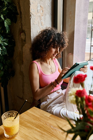 A woman in stylish attire enjoys a moment of peace while browsing on a tablet in a European cafe.