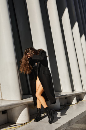 A woman in a black coat dances on the streets of New York City.の写真素材