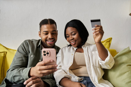 A happy couple makes a purchase together at home.の写真素材