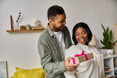 A man gives a gift to a woman in their home.の写真素材