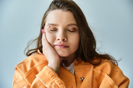 A young woman with long brown hair, wearing a stylish orange jacket, in a studio setting.の写真素材