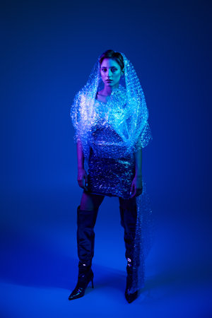 Woman confidently wears bubble wrap dress in studio, showcasing sustainable fashion beauty
