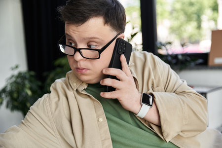 A young man with Down syndrome uses his phone.