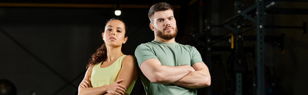A male trainer teaches self-defense techniques to a woman in a gym.の写真素材