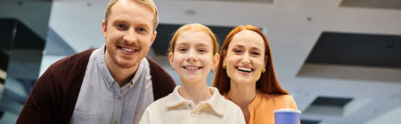 A happy family stands beside each other, enjoying a day out at the cinema.の写真素材