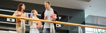 A happy family standing together, enjoying a moment of togetherness at the cinema.
