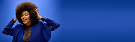Stylish African American woman gracefully holding her hair up to her head.