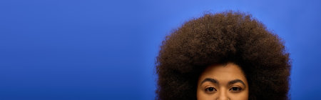 Stylish African American woman in trendy attire making a funny face with her afro hair.の写真素材