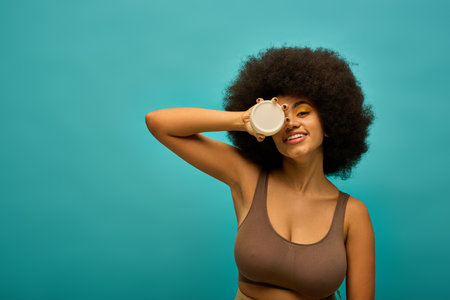 Stylish woman with curly hairdo holding cream.の写真素材