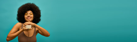 Stylish African American woman with curly hairdo holding cream.の写真素材