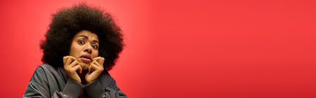 A woman with a voluminous afro pulls a comical facial expression.の写真素材