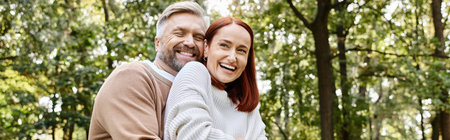 A man and a woman in the woods, smiling lovingly on a walk.の写真素材