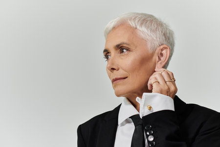 Confident woman with short hair showcases chic fashion in a serene setting.