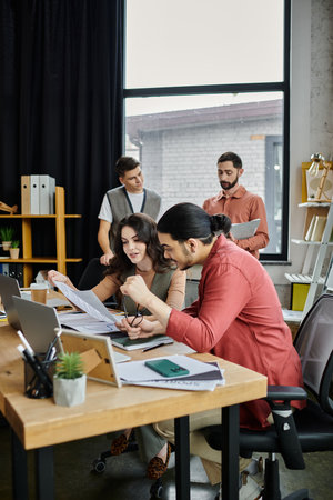 Team members engage in candid conversation in office.の写真素材