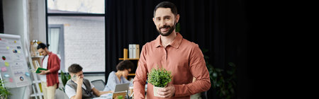 Professional man packing his belongings during lay off in modern office, colleagues on backdrop.の写真素材