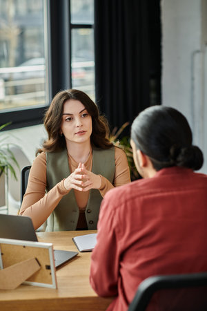 Professionals engage in a serious conversation about layoffs in a modern workspace.の写真素材