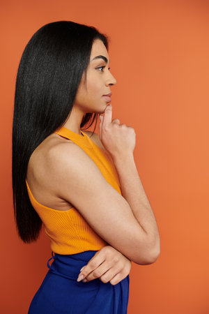 A woman contemplates deeply with a thoughtful expression and vivid colors.の写真素材