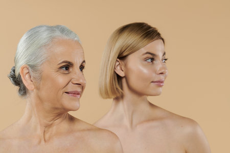 A mature woman stands with her adult daughter, sharing a joyful connection.の写真素材