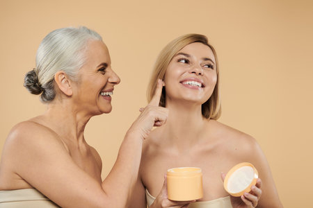 A mother and daughter share smiles while skincare bonding.の写真素材