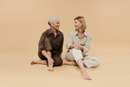 Two generations share smiles and laughter in a cozy, warm toned space.の写真素材