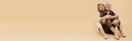 A mature woman shares laughter and warmth with her adult daughter.の写真素材