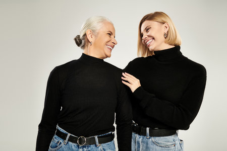 A warm exchange of smiles between a mother and her adult daughter.