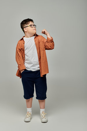Adorable little kid with Down syndrome wearing glasses poses for the camera.の写真素材