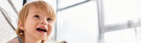 A little girl with a surprised expression standing in front of a window at home.の写真素材