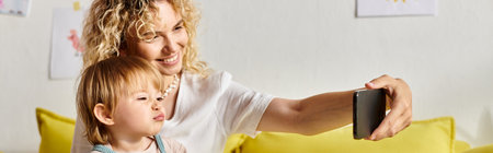 A curly mother and her toddler daughter engrossed in a selfie, sharing laughter and bonding