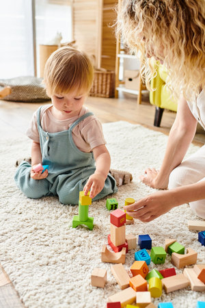 Curly-haired mother lovingly engaging with her toddler daughter using Montessori education method at home.の写真素材