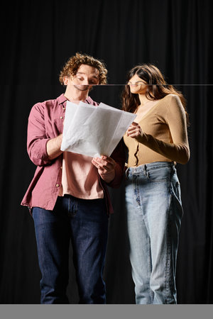 A handsome man and a beautiful woman standing together in a theater rehearsal.の写真素材