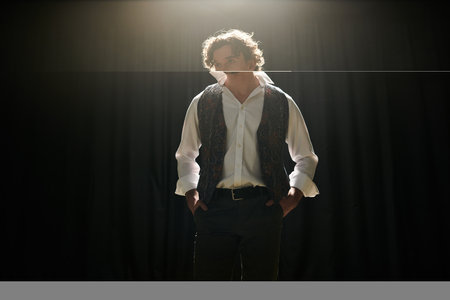 A man stands confidently in front of a black backdrop.の写真素材