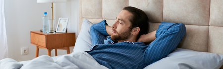 A man peacefully lying in bed with head on pillow.