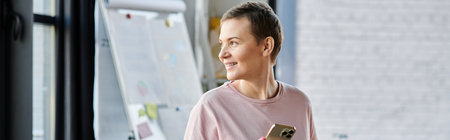 Dedicated businesswoman in pink shirt gazes out window.
