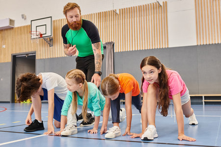 A diverse group of kids, coached by a man, performing push-ups on a gym floor with determination and focus.の写真素材