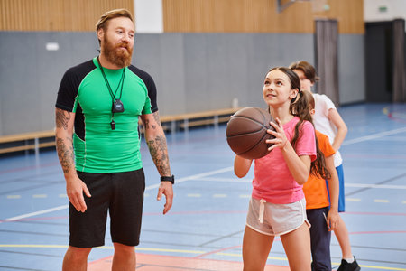 A man stands next to a girl, holding a basketball in his hand in a dynamic and engaging moment.の写真素材