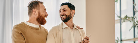 Two men share a delightful moment, smiling at each other in front of a bright window in a modern...