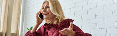 A mature woman in a stylish dress talks on her cellphone.